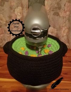 a kitchen aid hand mixer sitting on top of a pot holder with a flower design