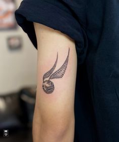 a tattoo on the arm of a woman with an owl head and wing design in black ink