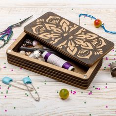 a wooden box filled with craft supplies on top of a table