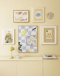 there are many pictures on the wall above the dresser in this room, including lemons and gingham