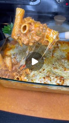 a glass casserole dish filled with pasta and cheese being lifted by a spatula