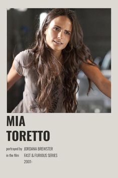 a woman with long hair standing in front of a white sign that says mia toretoo