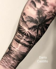 a man's arm with a palm tree on the beach