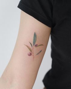 a woman's arm with a small flower tattoo on the left side of her arm