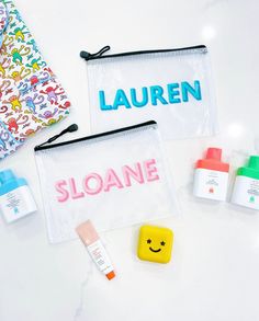 the contents of a personal care bag are laid out on a white surface, including toothbrushes and lotion