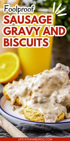 a plate with biscuits covered in gravy next to a glass of orange juice