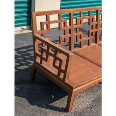 a wooden bench sitting on top of a parking lot