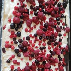 a pan filled with berries and cream on top of a table