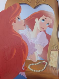 the little mermaid is looking at her reflection in the mirror with pearl necklace on it