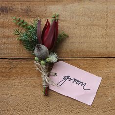 a boutonniere with some flowers on it and a note attached to it