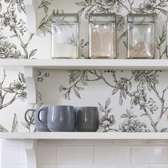 the shelves are filled with glass jars and mugs, along with other kitchen items