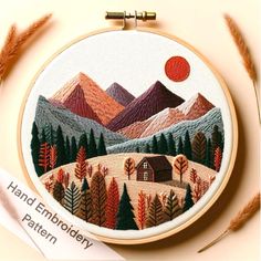 an embroidery project with mountains and trees in the background