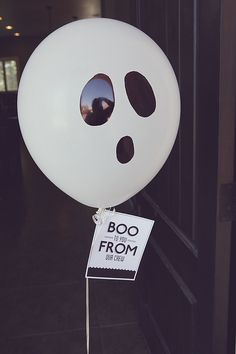 a white balloon with a face drawn on it and a sign that says boo from the inside out