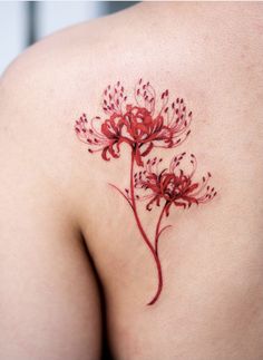 the back of a woman's shoulder with red flowers on her left arm and chest