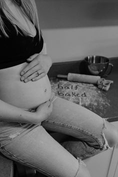 a pregnant woman sitting on top of a counter