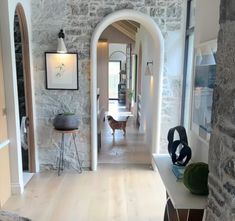 a dog is standing in the hallway between two archways and a table with chairs