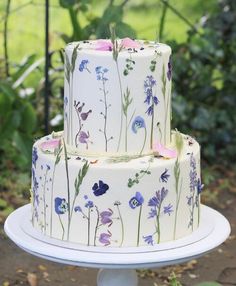 a three tiered cake with purple flowers on it