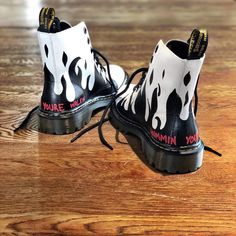 DESCRIPTION Black flames painted along the entire bottom of boots, with the words 'now you're walkin' painted in small font on one, and 'hummin your song' painted in small font on the other (in red on both). Painted on white Dr Marten boots. Runs true, but if you are half size, we recommend sizing down. Unisex. Signed @wrenandglory FREE SHIPPING *Final Sale* EACH PIECE IS MADE TO ORDER, HAND PAINTED BY GLORIA AND HER TEAM IN THEIR NYC STUDIO. Nyc Studio, Small Font, Hot Boots