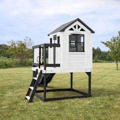 a white and black play house in the middle of a field