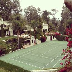 a tennis court surrounded by trees and bushes