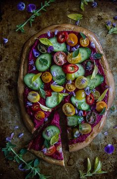 a pizza topped with lots of veggies on top of a table