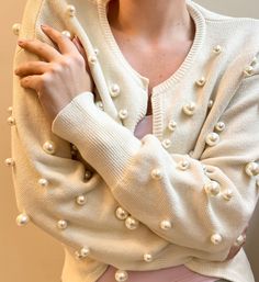 The Perla cardigan is beautifully made statement piece, handmade with dozens of large pearls. Dress it up or dress down, this is a must-have for every wardrobe. Jumbo pearl detailing Hook and eye closure One size fits most - ideal for sizes S to L 100% Cotton wool blend Made in UK Measurements shoulder 58cm, bust 120cm, sleeve 52cm, length 58cm Dubai Bling, Pearls Dress, Pearl Cardigan, Bedazzled Jeans, Hand Dress, Fashion Accessories Trends, Beautifully Made, Rhinestone Trim, Hook And Eye