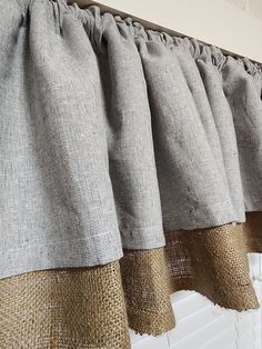 some burlap curtains hanging on the side of a window