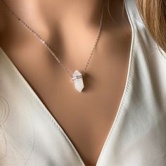 Introducing the Delicate Moonstone Crystal Necklace by Asana Crystals, a mesmerizing piece of jewelry that exudes elegance and enchantment. This stunning crystal necklace features an authentic moonstone crystal point pendant, delicately adorned with sparkling cubic zirconia accents, suspended from a high-quality 925 sterling silver chain. The moonstone crystal necklace is known for its ethereal beauty and its connection to the soothing energies of the moon. Its captivating iridescence reflects a soft glow, creating a sense of tranquility and inner peace. The addition of cubic zirconia adds a touch of glamour and sophistication, making this necklace a perfect accessory for both formal occasions and everyday wear. Delicate Pendant Crystal Necklace With Clavicle Chain, Crystal Pendant Necklace As Gift For Her, White Sterling Silver Pendant Crystal Necklace, White Sterling Silver Crystal Pendant Necklace, Diamond White Crystal Necklace For Gift, Minimalist Gemstone Pendant Crystal Necklace, Crystal Clavicle Chain Necklace As Gift, Crystal Clavicle Chain Necklace For Gift, White Clavicle Chain Crystal Necklace As Gift