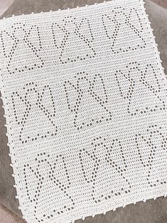 a white crocheted doily with the word love written on it, sitting on a table