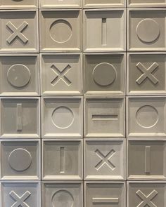 the letters and numbers are arranged in rows on the white tile wall behind them is an xoxo symbol