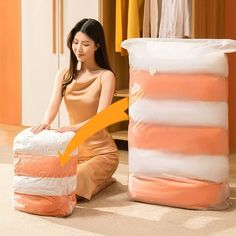 a woman sitting on the floor next to a pile of clothes and bags with an orange arrow pointing at it