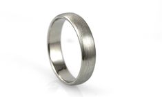 a plain wedding ring is shown on a white background, with the edge slightly down