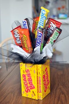 a box filled with candy sitting on top of a wooden table