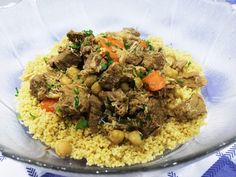 a bowl filled with rice and meat on top of a blue tablecloth covered table