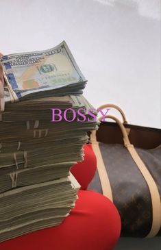 a stack of money sitting on top of a suitcase next to a purse with the word bossy written above it