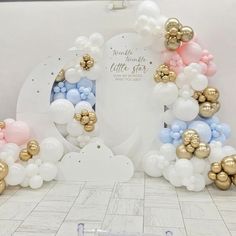 there is a large balloon arch with gold and blue balloons on it in the room