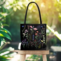 "Introducing our stunning black tote bag adorned with a beautiful wildflower design. This tote bag is not only a fashionable accessory but also a functional companion for your daily adventures. The captivating wildflowers printed on the bag exude a sense of natural beauty and freedom, making it a perfect choice for nature lovers and those who appreciate the enchantment of the outdoors. Crafted with durable and high-quality materials, this tote bag is designed to withstand the demands of your busy lifestyle. Its spacious interior offers ample room for your essentials, whether you're heading to work, running errands, or enjoying a leisurely stroll in the park. The sturdy handles ensure comfortable and convenient carrying, while the black color adds a touch of elegance to your ensemble. This Black Tote Canvas Bag For Spring, Black Floral Print Tote Bag, Handmade Black Bags For Spring, Everyday Black Bag With Floral Print, Black Bags With Floral Print For Gifts, Handmade Black Canvas Bag As Gift, Handmade Black Canvas Bag For Gift, Handmade Black Canvas Bag Gift, Handmade Black Canvas Bag For Gifting