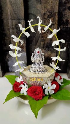 there is a cake decorated with flowers and an idol on it's stand in front of a wooden wall