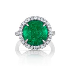 Sophisticated elegance in this platinum ring centering a 9.84-carat cabochon cut Colombian emerald nestled in a halo of 0.68 total carats of round brilliant cut diamonds that continue down the band. GIA certified. Reference Code: 21944 Shop other beautiful pieces in our Ring Collection. For inquiries on the piece please contact: boutique@shsilver.com Luxury Green Halo Ring In Fine Jewelry Style, Formal Round Emerald Ring With Halo, Luxury Round Emerald Ring With Halo, Emerald Halo, Tsavorite Garnet, Diamond Halo Ring, Colombian Emeralds, Ring Collection, Halo Diamond Ring