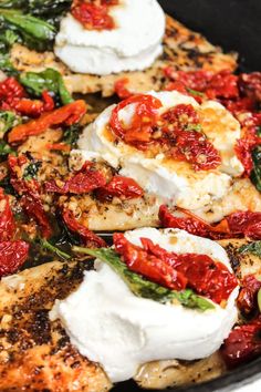 chicken with tomatoes, mozzarella and spinach in a skillet