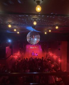 a disco ball hanging from the ceiling in front of a group of people at a party