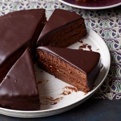 there is a chocolate cake on the plate with one slice cut out and ready to be eaten