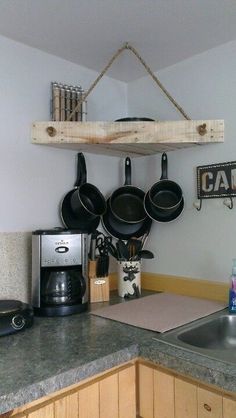 pots and pans are hanging on the wall above the kitchen sink