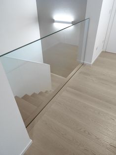 an empty room with wooden floors and glass balconies on the wall above it