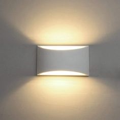 a white wall light that is on the side of a wall with two lights above it