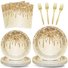 a set of four plates with gold sequins on them and forks next to each other