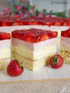 three slices of cake with strawberries on the side