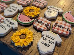 some decorated cookies are on a table with watermelon and sunflowers in the background