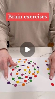 a person holding a piece of paper with colored dots on it and the words brain exercises in front of them