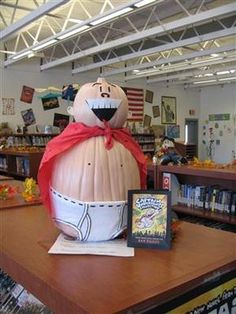 an inflatable pumpkin sitting on top of a table next to a book shelf